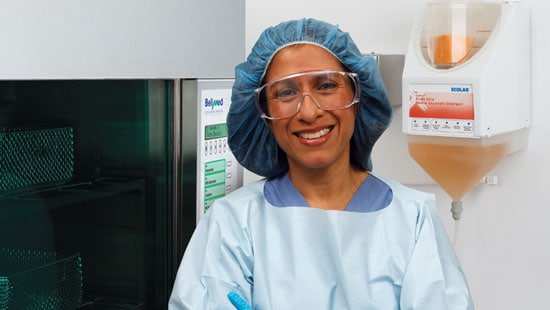 Instrument Reprocessing - woman in Central Sterile standing in front of OptiPro Single Solid Dispenser