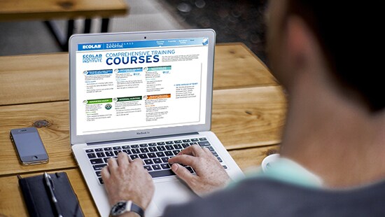 Browsing Ecolab training courses on a laptop