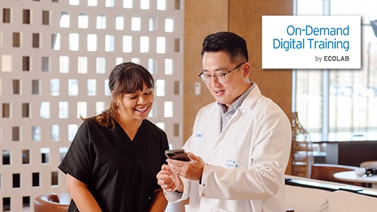 Hotel employee looking at On-Demand Digital Training with an Ecolab Expert and the On-Demand Digital Training logo displayed