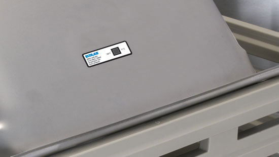 Ecolab dishwasher temperature labels on the panel of a stainless-steel dishwashing machine.