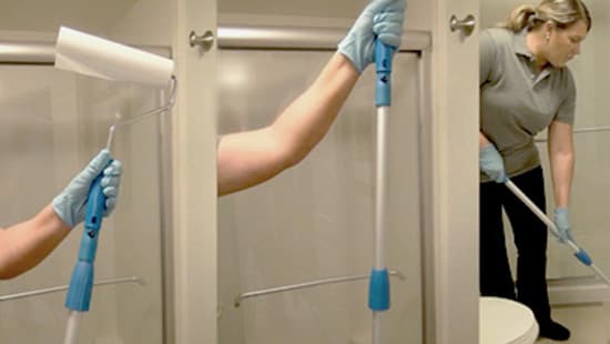 Hospitality housekeeper fastening a cleaning roller onto a pole and wiping the restroom floor
