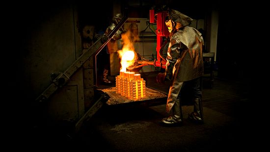 Worker pouring material into casting mold.
